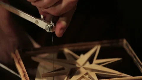 Young artisan draws a wind rose shape out of a board of wood with a fretsaw Stock Footage 100978008