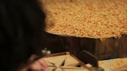 Young artisan draws a wind rose shape out of a board of wood with a fretsaw Stock-Footage 100978461