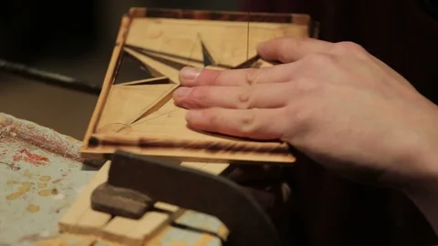 Young artisan draws a wind rose shape out of a board of wood with a fretsaw Stock Footage 100980316