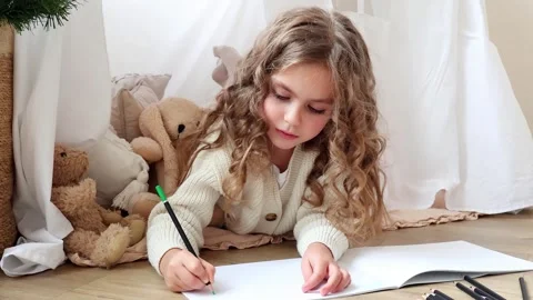 Young artist captures imagination while drawing in cozy space 스톡 동영상 296323556