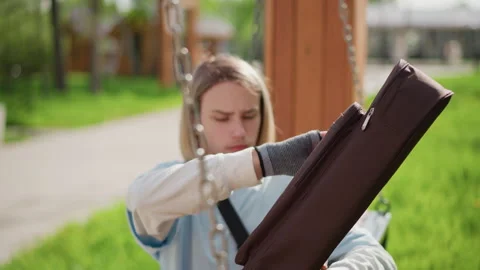 Young artist carefully checking strings before performing outdoors. Musician in Stock Footage 327985686