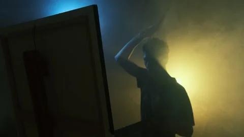 Young artist caught in creative flow, painting with passion in moody cinematic Stock Footage 314391296