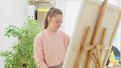 Young artist in studio drawing work. Female artist painting picture on canvas Video stock 269777441