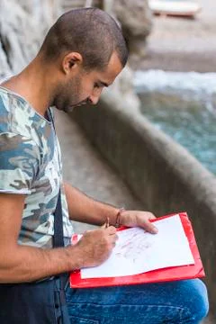 Young artist while drawing. Stock Photos