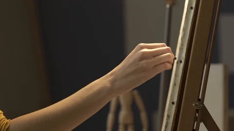 Young artist working in the studio and painting on canvas Stock Footage 127418027