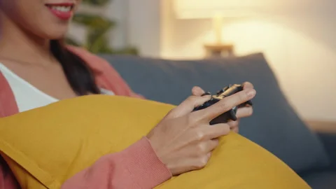 Young Asia lady using controller play video game having funny happy on sofa. Stock Footage 149916551