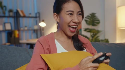Young Asia lady using controller play video game having funny happy on sofa. Stock Footage 149924209
