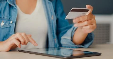 Young asia lady using tablet order online shopping product and paying bills.. Stock Photos