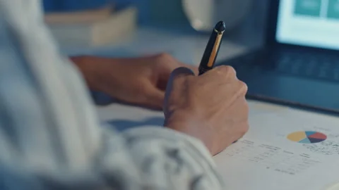 Young asia lady write worksheet finance graph account in laptop at house. Stock Footage 153220766