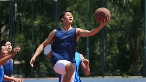 Young asian adults playing basketball Stock Footage