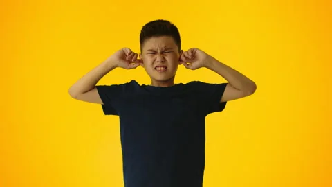 Young asian boy doesn't want to hear about anything and plugs his ears with her Stock Footage 249761808