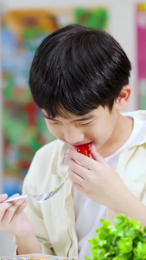 Young Asian Boy Eating a Cherry Tomato and Making a Face Video stock 329607199
