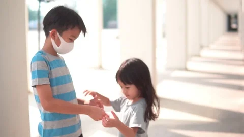 Young Asian boy give a face mask to little girl Stock Footage 124367133