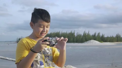 A young asian boy having fun and taking a photo with a camera Stock Footage 169272714