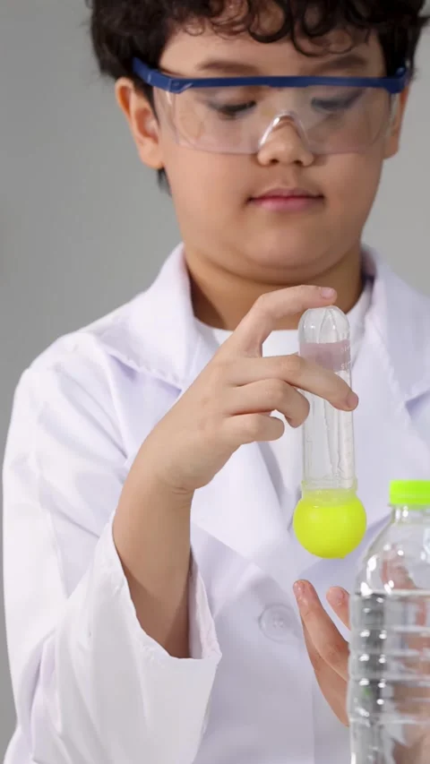 Young Asian Boy in Lab Coat Conducting Science Experiment with Test Tube Stock Footage 338155466