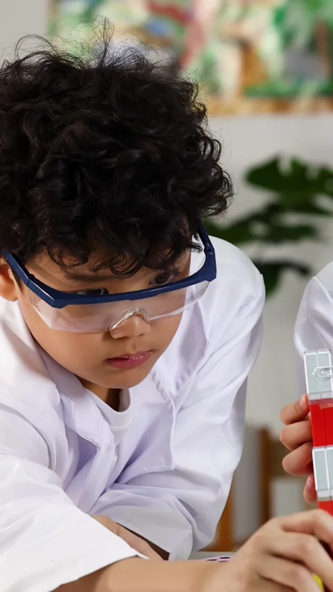 Young Asian Boy in Lab Coat Conducting Magnet Science Experiment Video stock 338155693