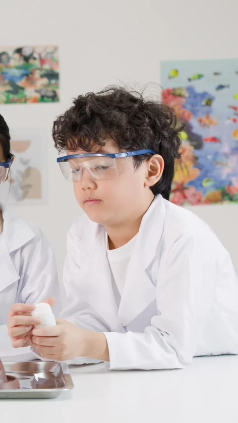 Young Asian Boy in Lab Coat Participating in Science Class Experiment Stock Footage 340243084