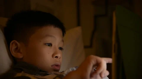 Young asian boy playing game on tablet computer Stock Footage 67302279