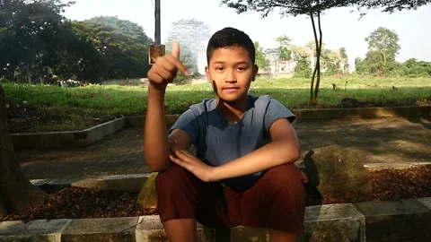 A young Asian boy is posing with various gestures for video footage. Stock Footage 279527775
