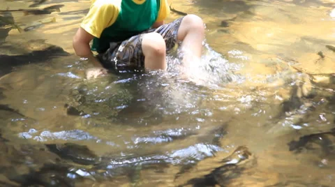 Young asian boy sitting in the river 库存影片 64620237