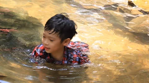 Young asian boy sitting in the river Stock-Footage 64620722