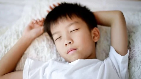 Young asian boy sleep on the bed and wake up Stock Footage 81028409