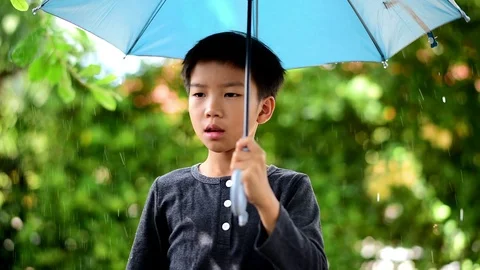 Young Asian boy stan under the rain Stock Footage 91090402