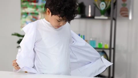 Young Asian Boy Taking Off White Lab Coat in Science Classroom Stock Footage 331900370