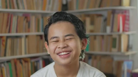 Young Asian boy talking to camera while standing inside library Video stock 146765690