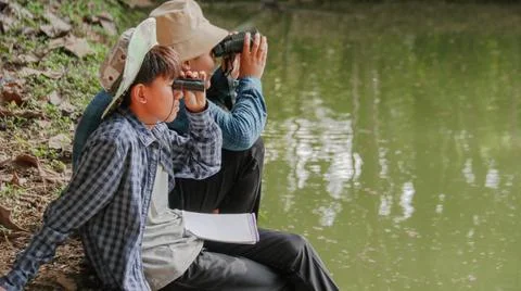 Young Asian boy is using a binocular to lookout for birds and animals Stock Photos
