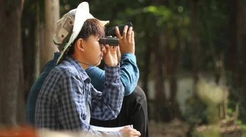 Young Asian boy is using a binocular to lookout for birds and animals Stock Photos