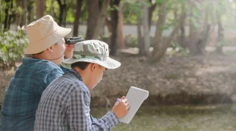 Young Asian boy is using a binocular to lookout for birds and animals Stock Photos