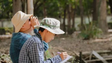 Young Asian boy is using a binocular to lookout for birds and animals Stock Photos