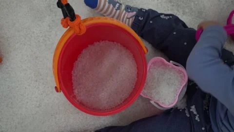 Young asian boy using a colorful shovel and bucket, playing with white sand Stock Footage 296891141