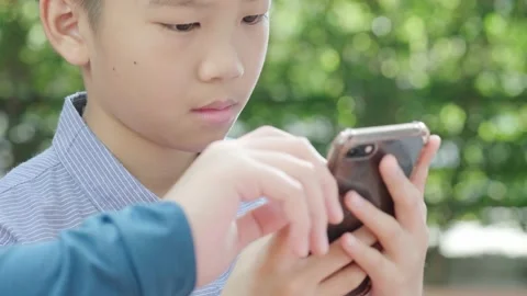 Young Asian boy using mobile phone Stock Footage 144855013