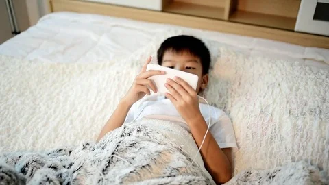 Young asian boy using smartphone on the white bed-1 Stock Footage 82447501