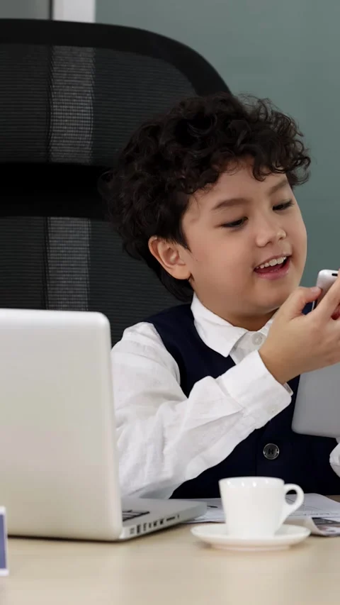 Young Asian Boy Using Tablet and Laptop in Modern Office Setting Stock Footage 337752101