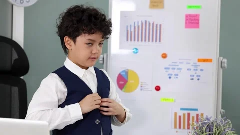 Young Asian Boy in Vest Adjusting Clothes Near Whiteboard with Charts Stock Footage 337009980