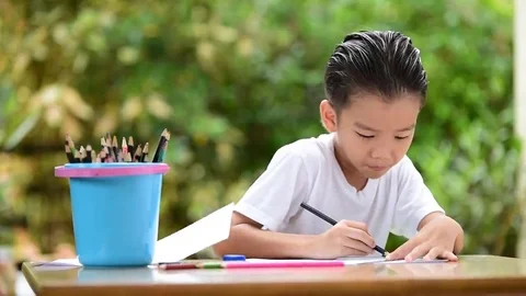 Young Asian boy write on the note book by color pencil Stock Footage 69217018