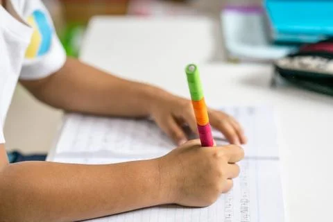 Young Asian boy write on the note book by pencil in the room Stock Photos