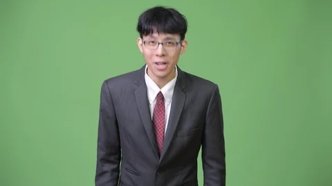 Young Asian businessman explaining while showing something to the back Stock Footage 90914425