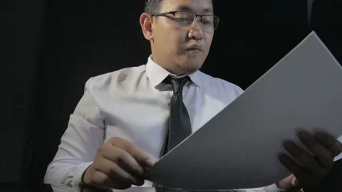 Young Asian businessman receiving document report from his staff, looking sat Stock Footage 140365553