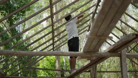 Young asian construction laborer working on a new house with a hammer Stock Footage 232581814