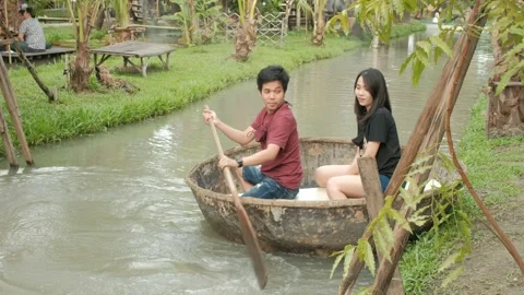 Young Asian couple are rowing a circle boat in a canal. Stock Footage 143817341