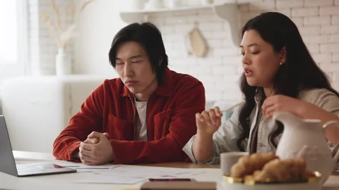 Young Asian couple feeling upset about low family budget, checking utility bills Stock Footage 330402283
