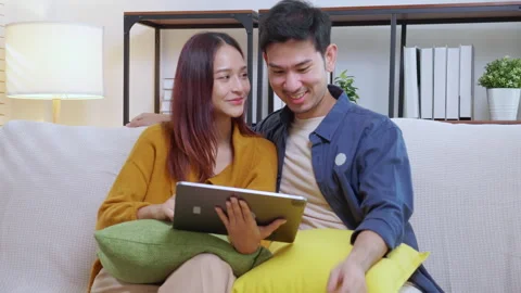 Young asian couple looking on tablet for relax with cozy and contentment si.. Vidéo 303222367