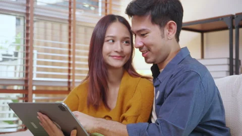 Young asian couple looking on tablet for relax with cozy and contentment si.. Vidéo 307190083