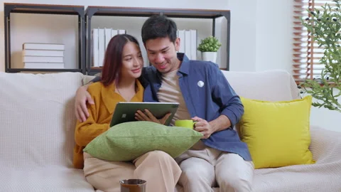 Young asian couple looking on tablet for relax with cozy and contentment si.. Vidéo 307193924