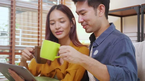 Young asian couple looking on tablet for relax with cozy and contentment si.. Vidéo 329457058
