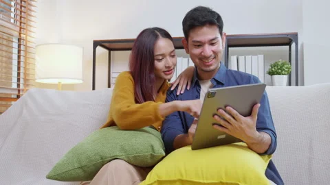 Young asian couple looking on tablet for relax with cozy and contentment si.. Vidéo 329457336